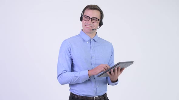 Young Happy Handsome Businessman As Call Center Representative Thinking While Using Digital Tablet