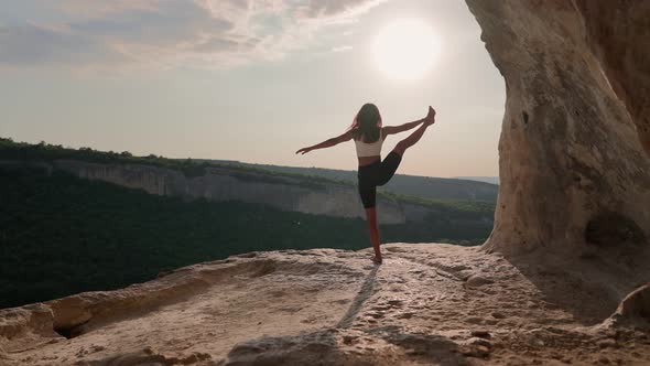 Athletic Woman Performs Spiritual Yoga Pose on Mountain Top Sunset