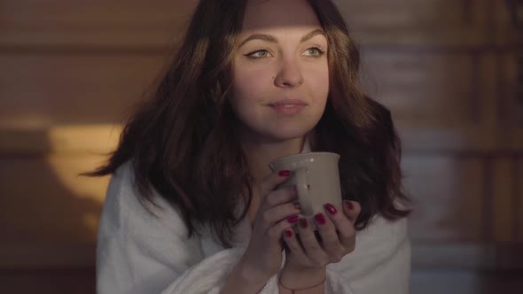 Portrait of Attractive Caucasian Brunette Woman Looking Away and Drinking Coffee