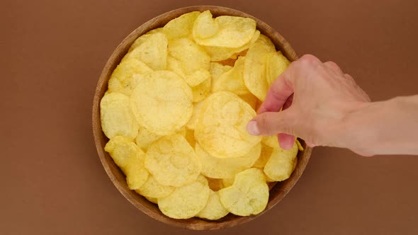 Potatoes chips. Hands of different people that take chips from bowl