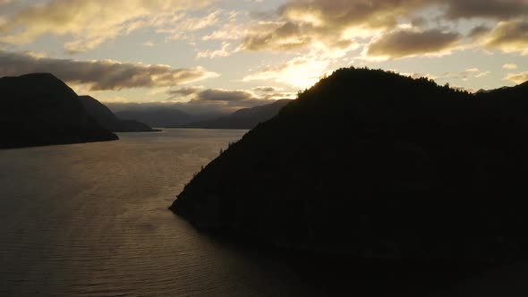 Aerial shot of the silhouette of hills beside Nahuel Huapi lake at sunset. Dolly left