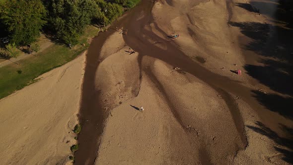 4K Hawker peddler walking by river shore selling ice cream. Aerial top down view. Cordoba in Argenti