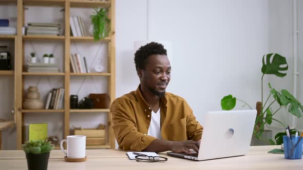 African Man Work at Laptop in Home Office
