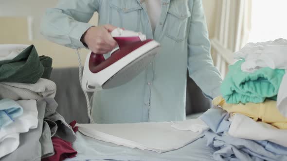 Happy Woman Ironing Her Clothes at Home