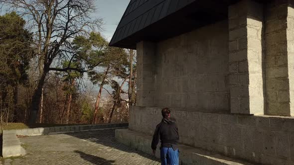 Aerial Drone Tracking Shot of a Young Adult Male Millennial doing a Flip off a Wall while Parkour Fr