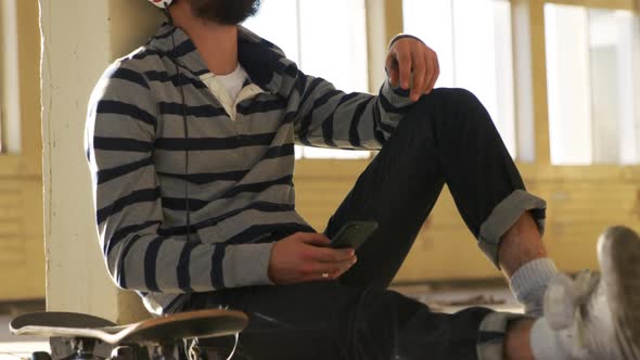 Young man listening to music in empty warehouse