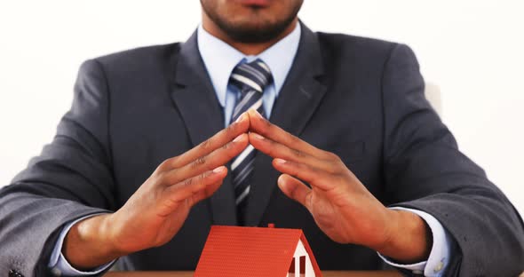 Portrait of businessman with house model