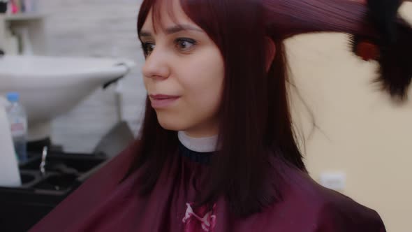 A Hairdresser Does Hair Styling for a Woman in a Beauty Salon