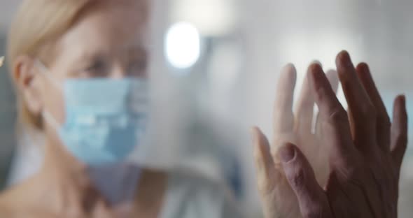 Husband Visiting Sick Wife in Mask Standing Behind Glass Door in Quarantine Ward
