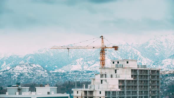 Construction Crane After Working Day Against Mountains Landscape