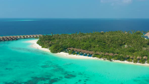 Aerial view on beautiful tropical resort island with water villas on Maldives