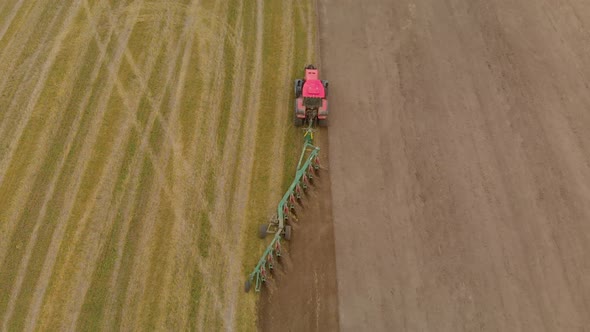 Tractor Cultivates Farmland with Modern Trailer Plow