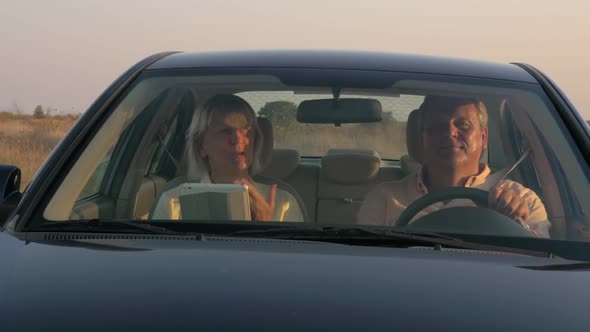 Senior Couple Traveling By Car in the Countryside