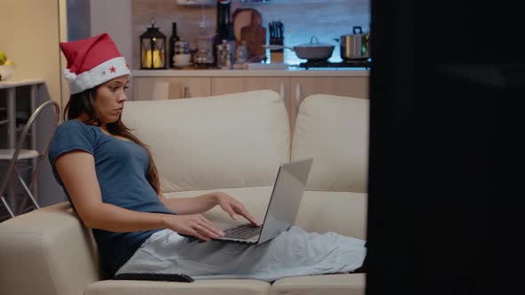 Festive Woman Working on Laptop While Watching Television