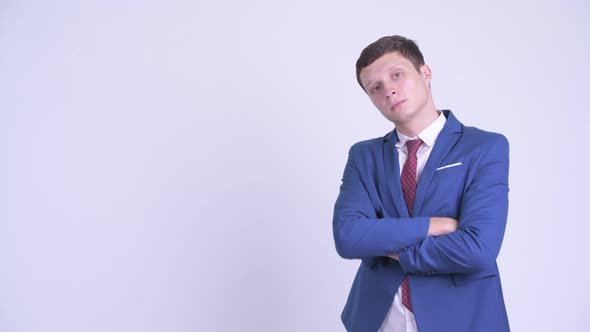 Profile View of Happy Young Handsome Businessman Smiling with Arms Crossed