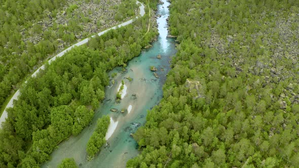 Aerial View Of Valldola River With Narrow Winding Road And Green Forest In Norway.
