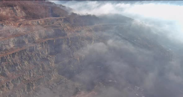 Aerial Drone View Morning View to Misty Over Autumn Forest Mountains with Open Pit Mine in a Quarry