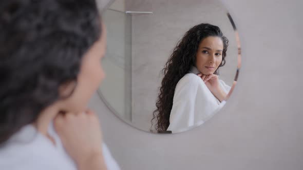 Young Woman in Bathrobe Looks in Mirror in Bathroom Attractive Confident Girl Admiring Reflection