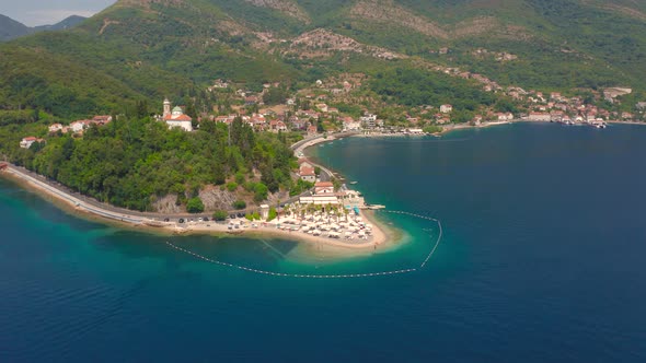 Aerial View of Huge Mountains and Small Sandy Beach of Kotor Bay Montenegro