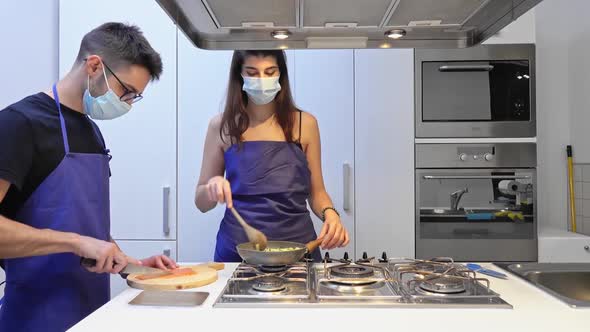 Couple with face mask prepares lunch in the kitchen