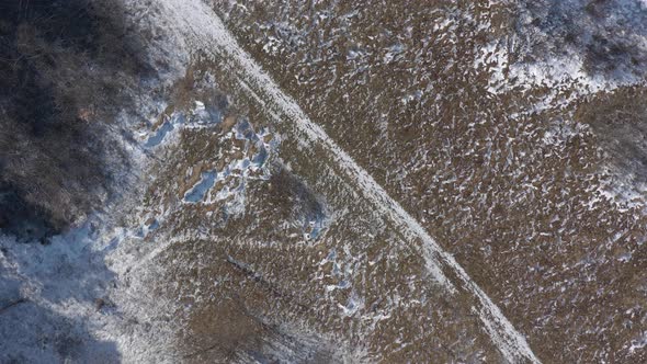 Partially snowed ground from above 4K aerial video