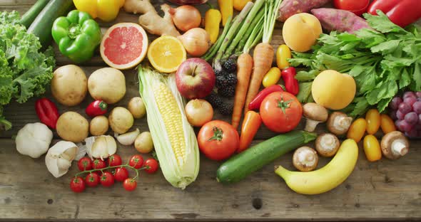 Video of fresh fruit and vegetables over wooden background