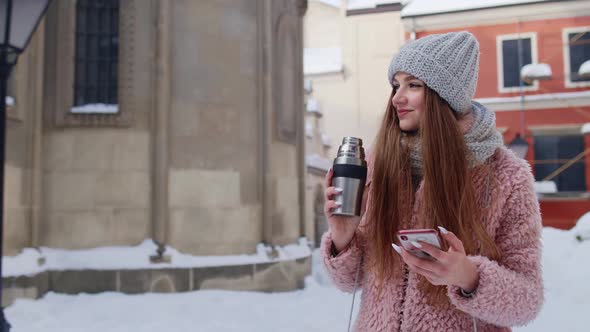 Young Traveler Woman Walking Along Old City Holding Mobile Phone Chatting with Friends and Family