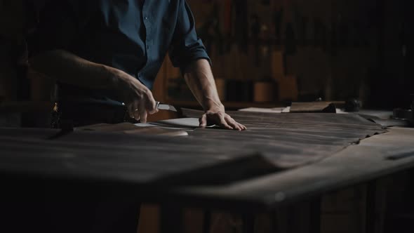 Close Up Shot of Unrecognizable Man Tailor Cutting Leather at Workshop Preparing Blanks for Shoe