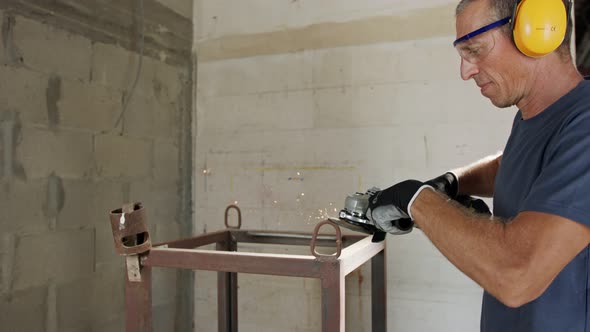 Man using a metal grinder on a metal object with sparks flying in slow motion