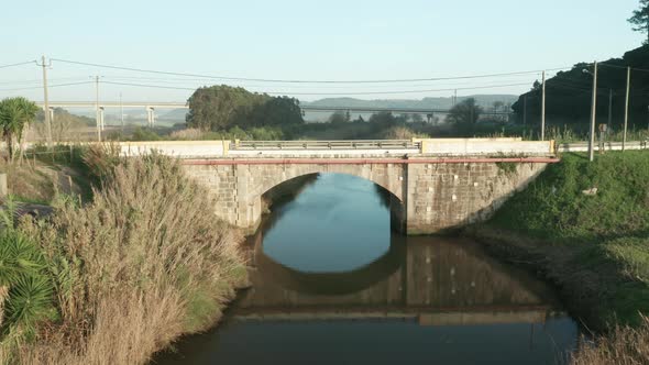 Reflections Through Calm River With Stone Arch Bridge During Daytime At Alcobaca River Near Nazare I