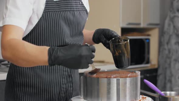 Confectioner Soaks the Top Biscuit of the Cake with Syrup