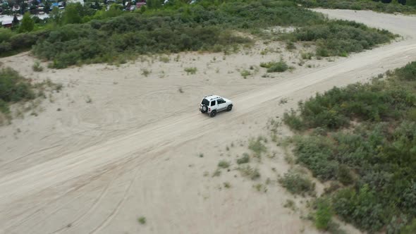 Aerial View of a Car Driving on Sand