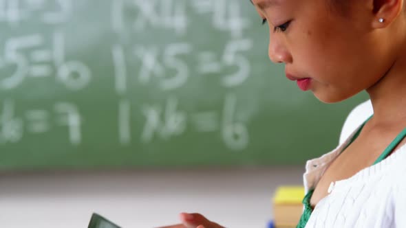 Schoolgirl using mobile phone in classroom