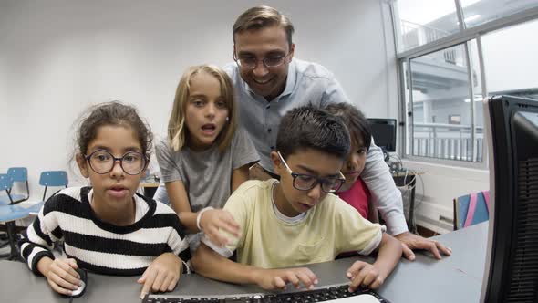 Male Teacher Laughing with Pupils at Computer Science Lesson