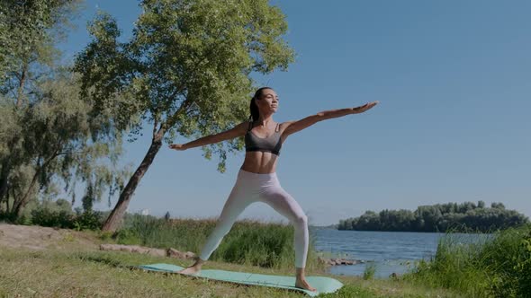 Young Beautiful African Girl Doing Yoga Warrior Pose on a Beautiful Day with Clear Blue Sky