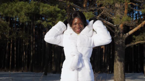 AfricanAmerican Girl Poses Against Trees in Winter Park