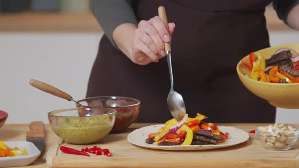 Woman Cooking Mexican Tacos at Kitchen Table