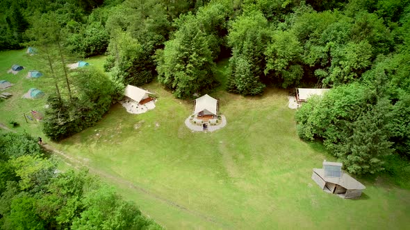 Aerial view of couple standing in front of sitting area at a camping site.