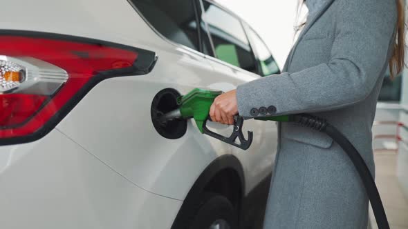 Woman Fills Petrol Into Her Car at a Gas Station. Slow Motion