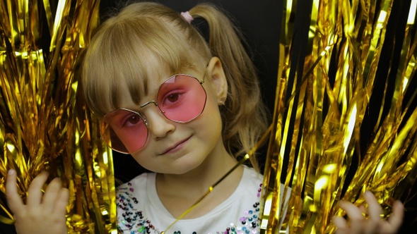 Portrait of Happy Child Playing, Fooling Around in Foil Fringe Golden Curtain. Little Blonde Kid