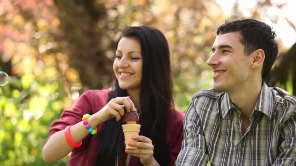 couple blowing soap bubbles in the park