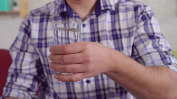 Shaking Hands of a Man Holding a Glass of Water Close Up