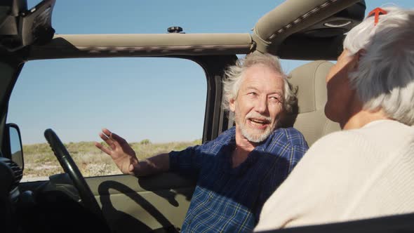 Senior couple talking in a car at the beach