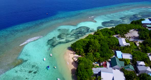 Daytime drone tourism shot of a sunshine white sandy paradise beach and blue sea background in vibra