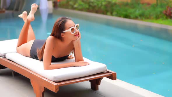 Young asian woman enjoy around outdoor swimming pool for leisure