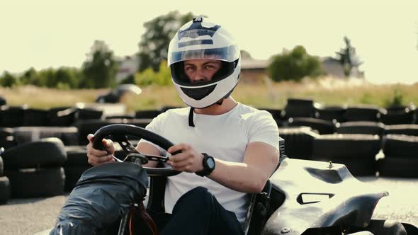 Attractive Man Sititng in a Gocart on the Track