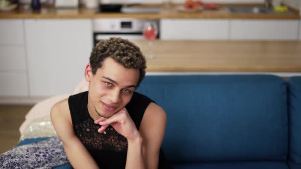 A Portrait of a Man in a Black Dress Looking to the Camera