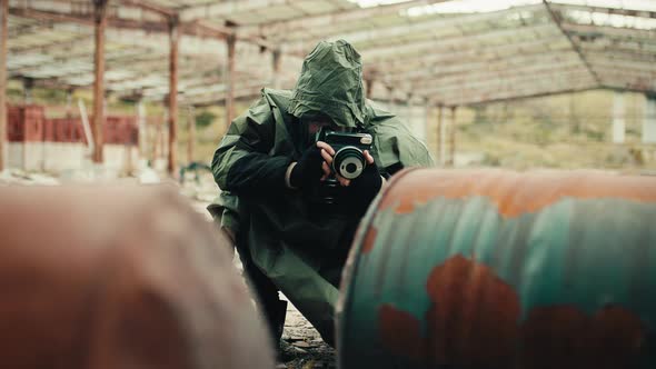 Military Man with Gas Mask and Camera Photographs the Destruction of the Bomb