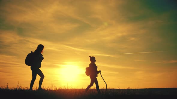 Silhouettes of Father, Mother and Children Hiking. Baby Sits on the Shoulders of His Father. Hiking