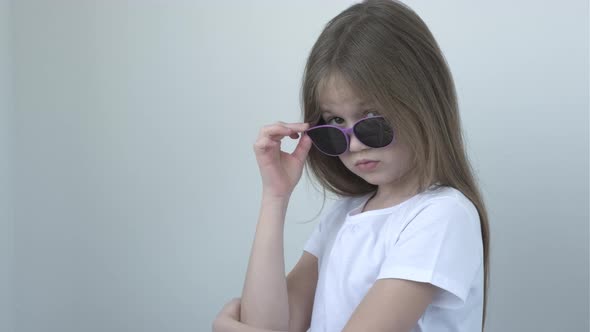 Cool Confident Little Girl with Takes Off Her Glasses and Looking at Camera